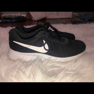 Black nike tennis shoes with white “swoosh”